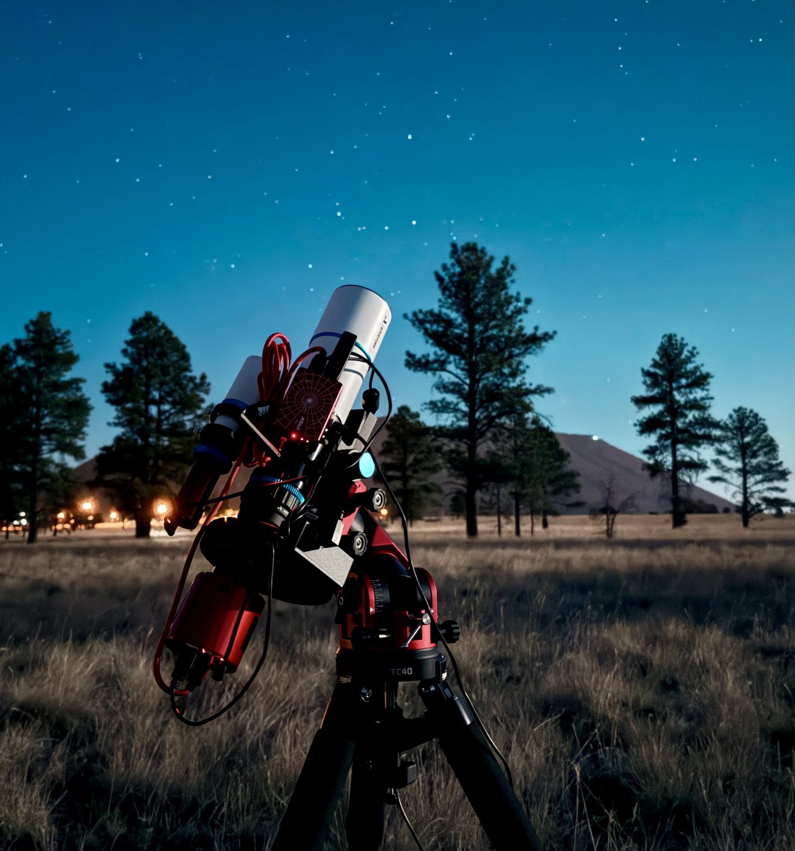 A small refractor on a portable equatorial mount under the deep-twilight sky outside Flagstaff, Arizona